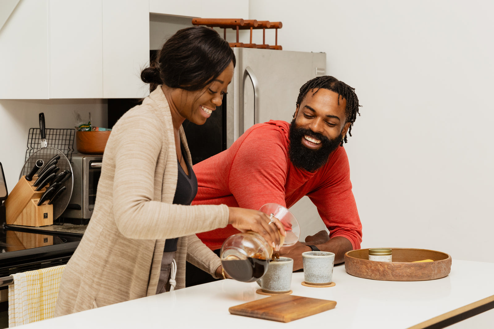 Two people making coffee together at home